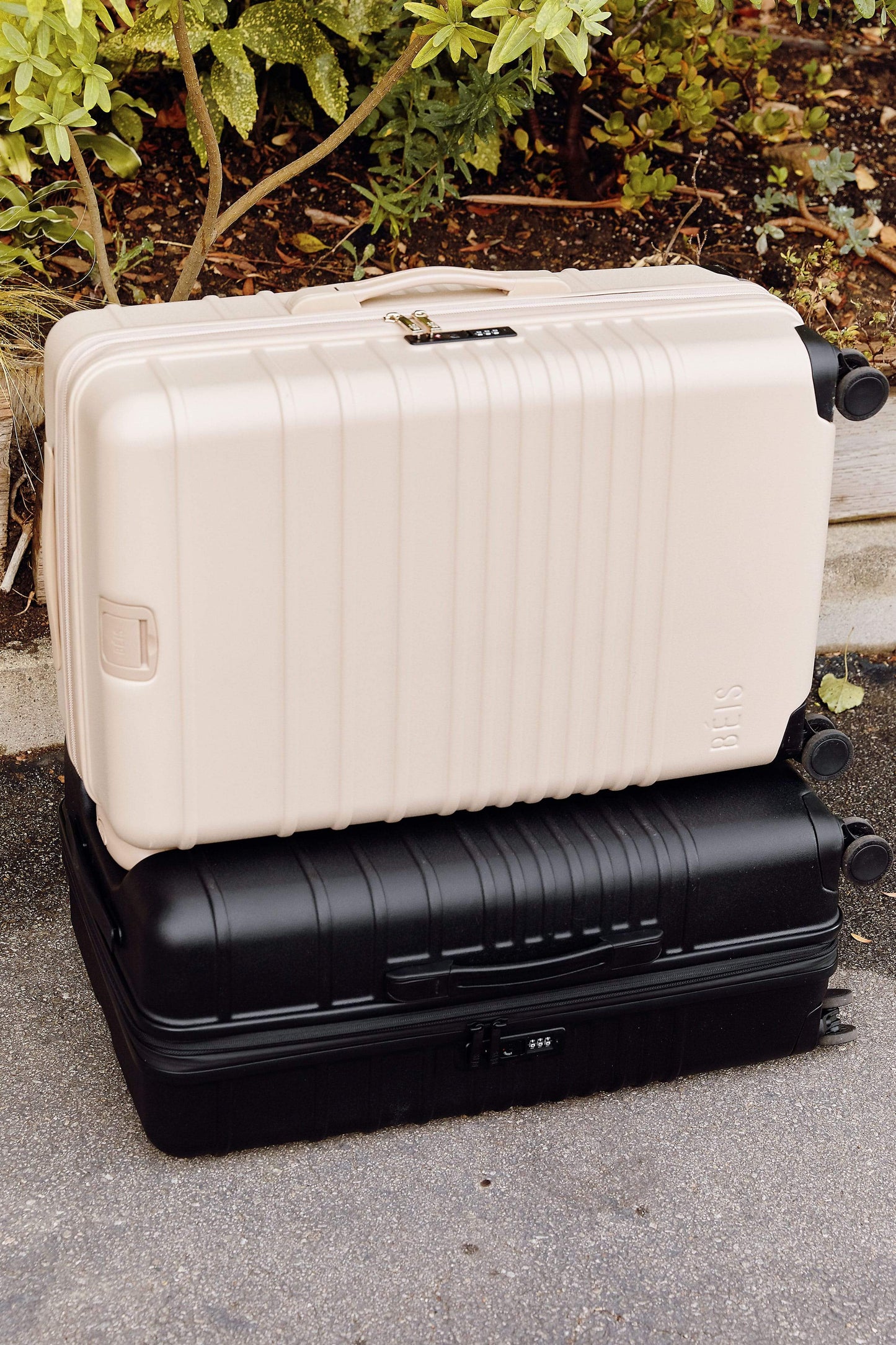 BEIS by Shay Mitchell | The 26" Check-In Roller in Beige on top of black luggage